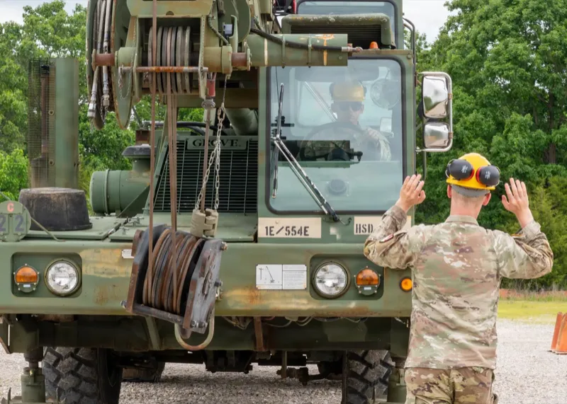 A Soldier ground-guides crane operations training at Fort Leonard Wood, Missouri. U.S. Army photo via DVIDS.